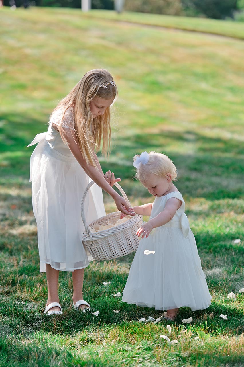 Flower girls scattering rose petals before an outdoor wedding ceremony in Sturbridge MA
