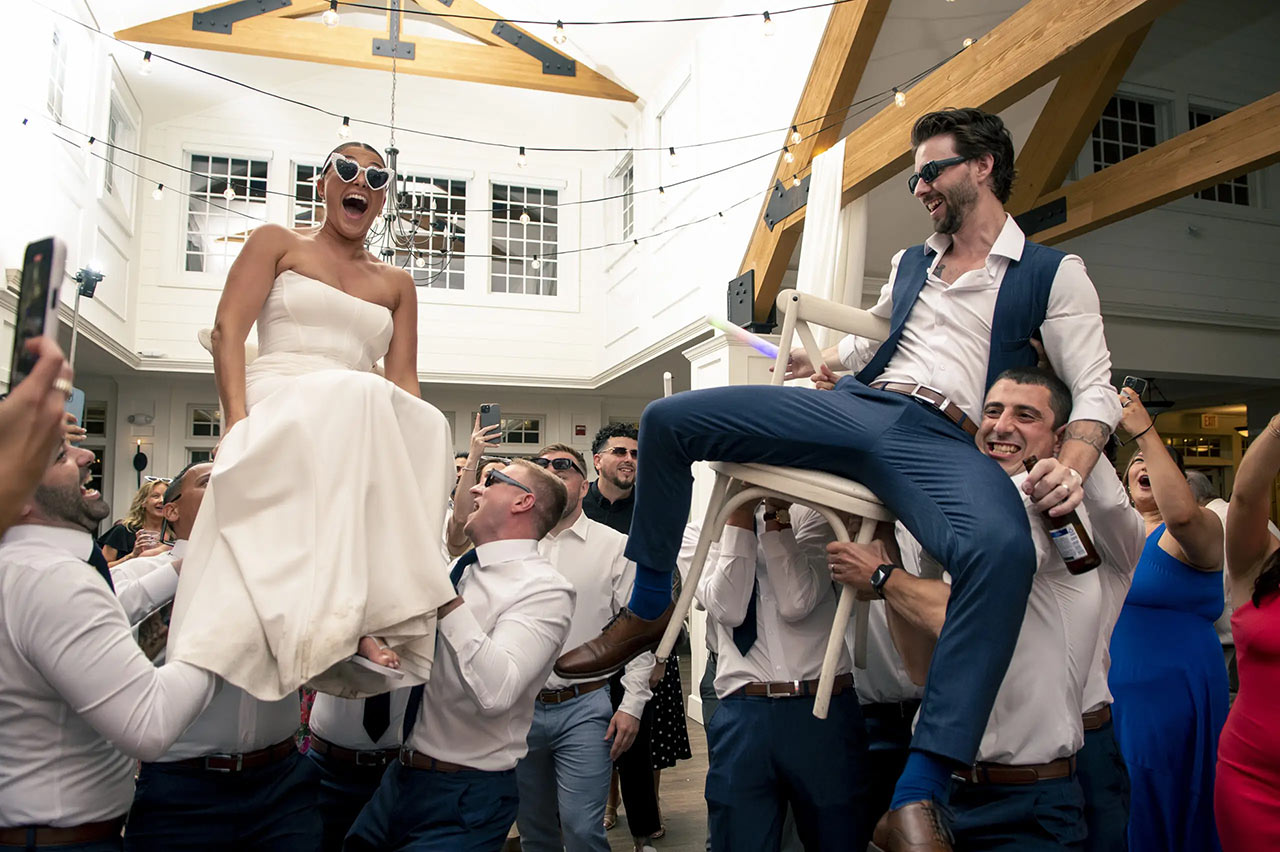 Bride and groom celebrating with their wedding party during a joyful wedding reception in Massachusetts