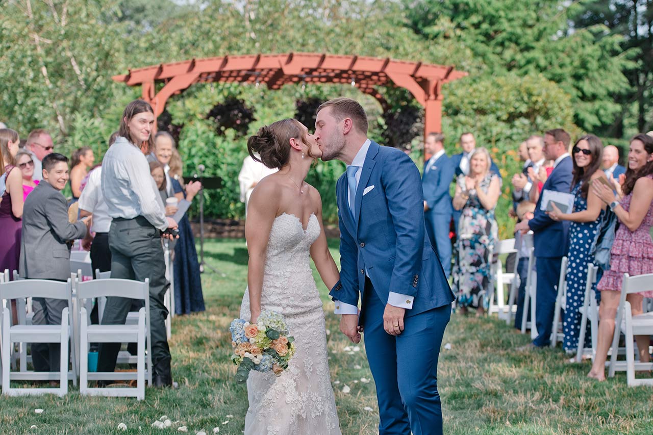 Newlyweds sharing a kiss after their outdoor wedding ceremony at Publick House in Sturbridge MA
