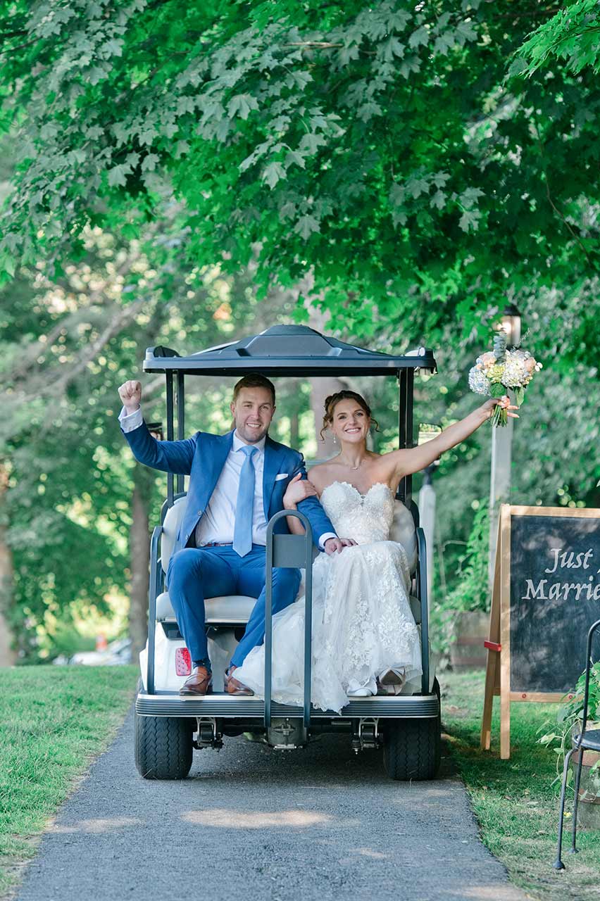 Newlywed bride and groom riding a golf cart at Publick House Historic Inn in Sturbridge MA