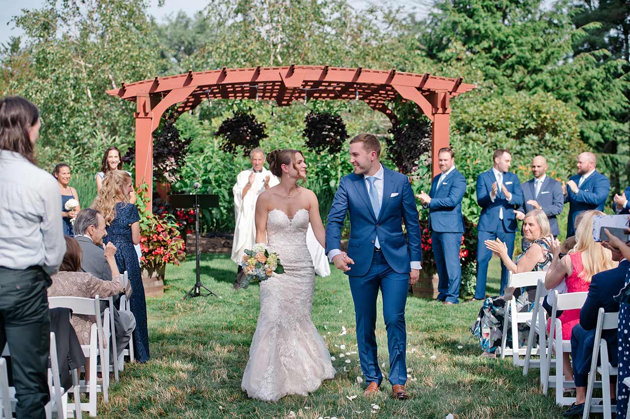 Newlywed bride and groom walking down the aisle after their outdoor wedding ceremony at Publick House in Sturbridge MA