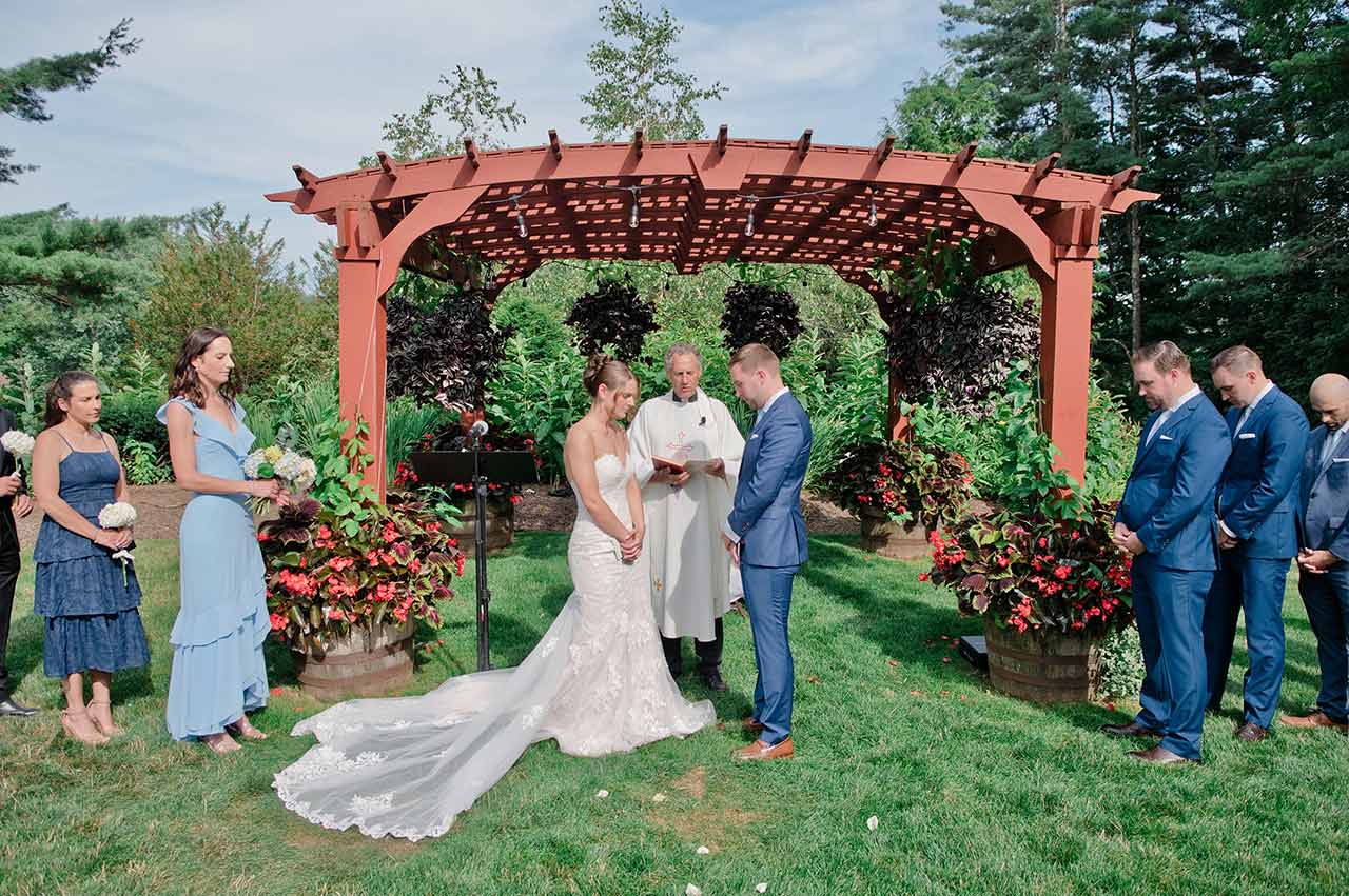 Bride and groom exchanging vows during an outdoor wedding ceremony in Sturbridge MA